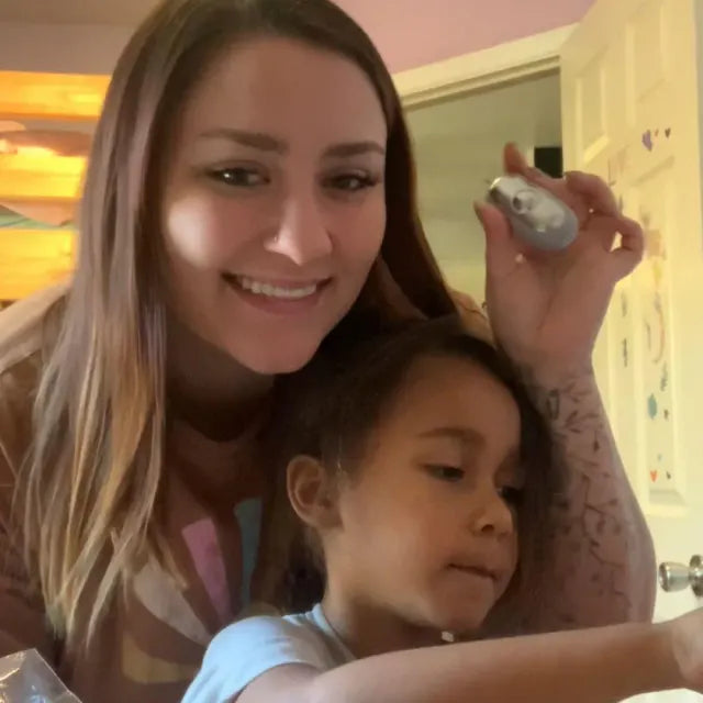 Une maman et sa fille ; la maman montre le CalmKid gris.
